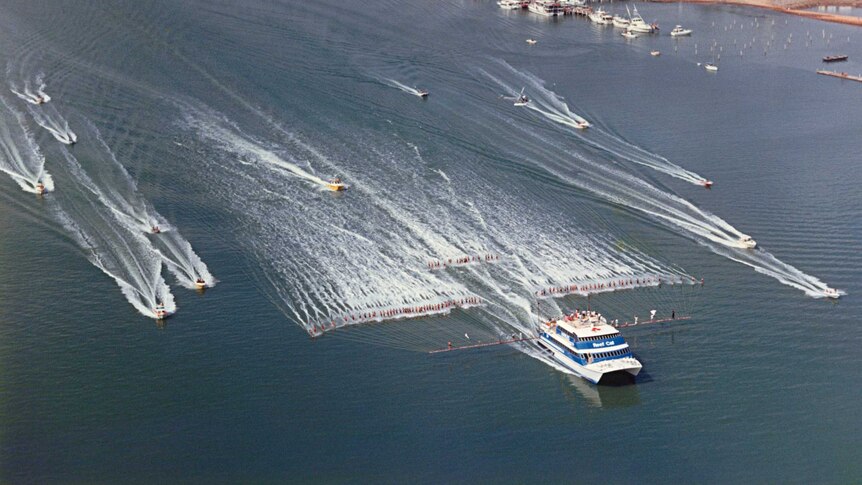 A small flotilla of boats trail behind 100 water-skiers attempting to set a new world record in Cairns on October 18, 1986.