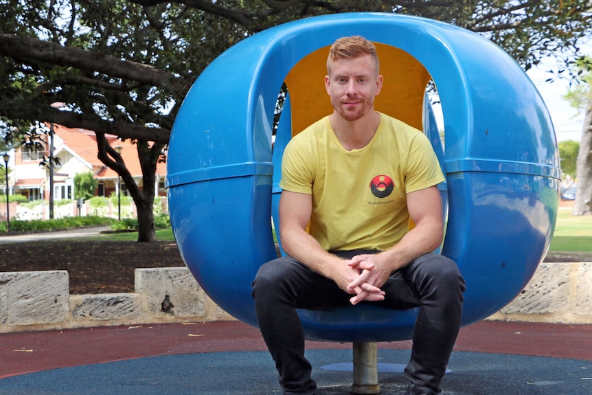 Wilson Tucker sitting in a blue chair in Perth's Hyde Park.