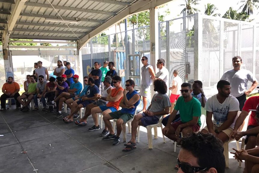 Asylum seekers stage a sit-in protest at the Manus Island detention centre. They are in a shady part of the compound.