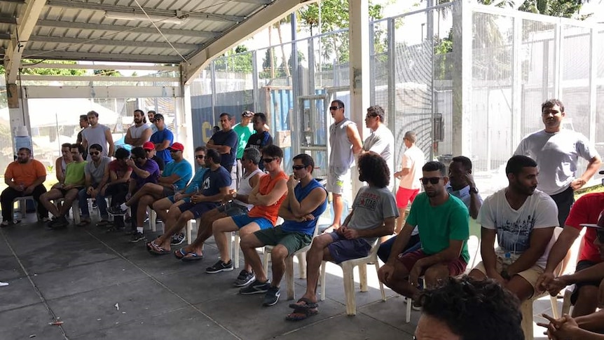 Asylum seekers stage a sit-in protest at the Manus Island detention centre. They are in a shady part of the compound.