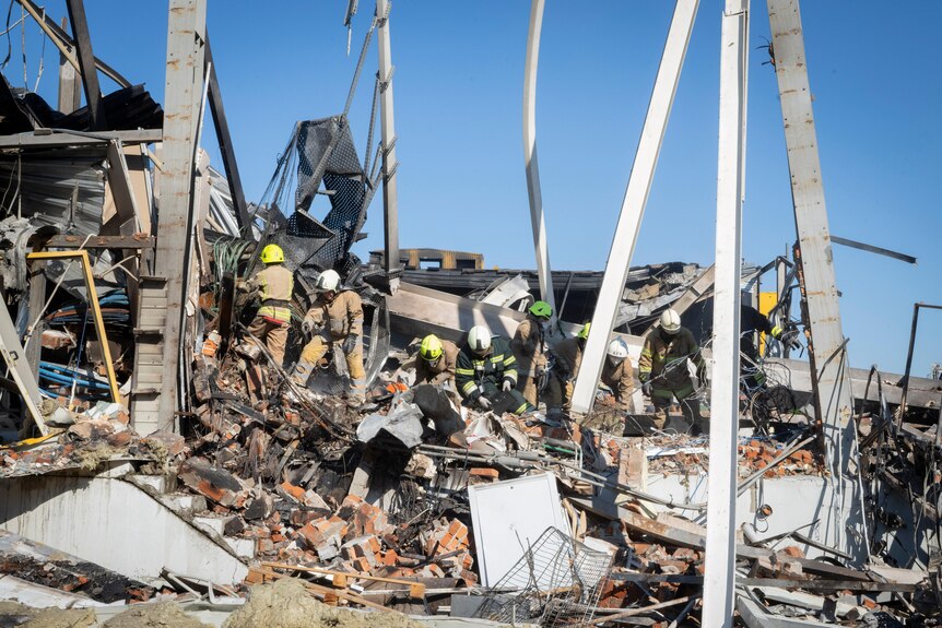 Firefighters search through the rubble of a shopping mall