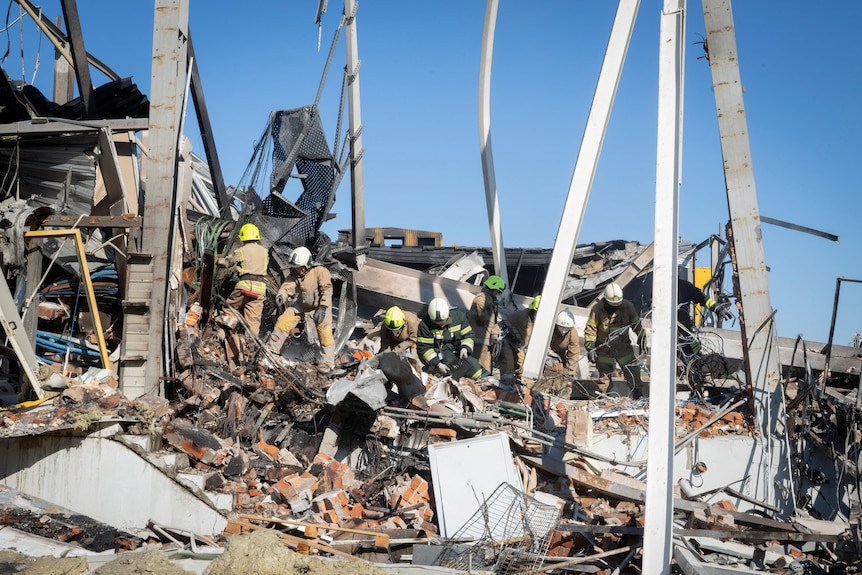 Firefighters search through the rubble of a shopping mall