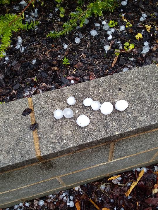 large balls of hail photographed on a concrete wall