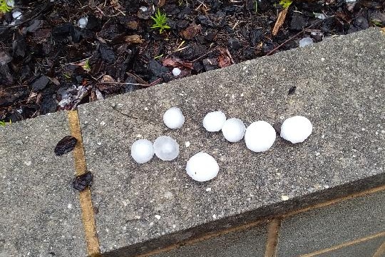 large balls of hail photographed on a concrete wall