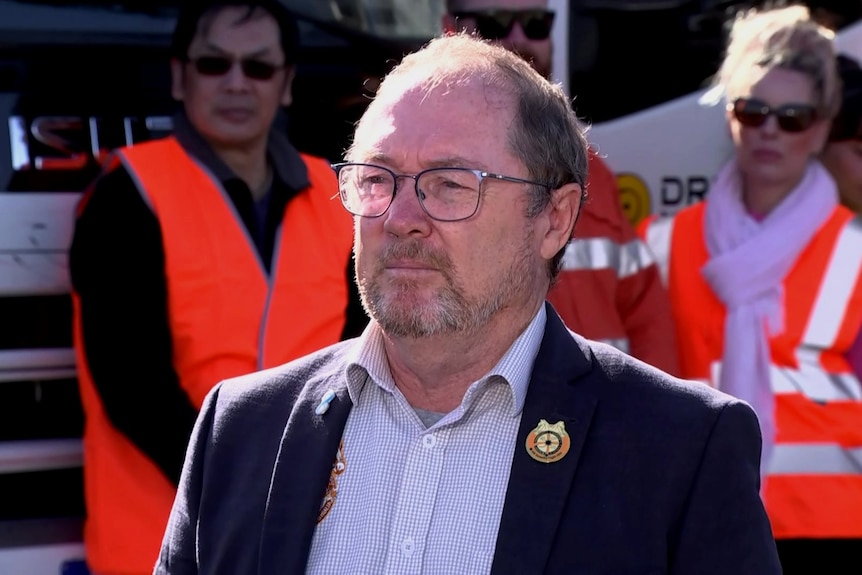 Tim Dawson pictured at a press conference in front of people wearing high vis