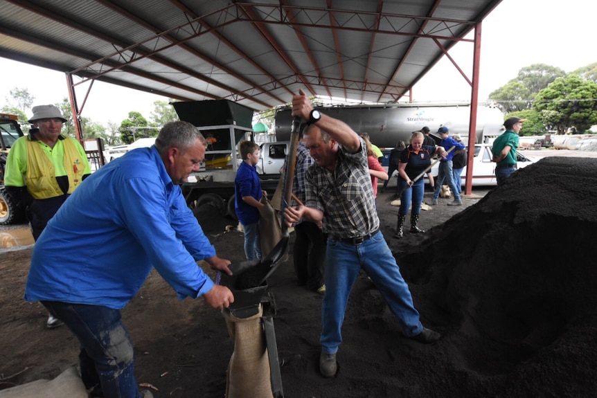 Local residents help each other fill sandbags at a depot in Euroa.