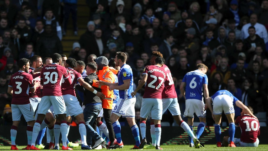 Players from Aston Villa (claret) and Birmingham City (blue) brawl