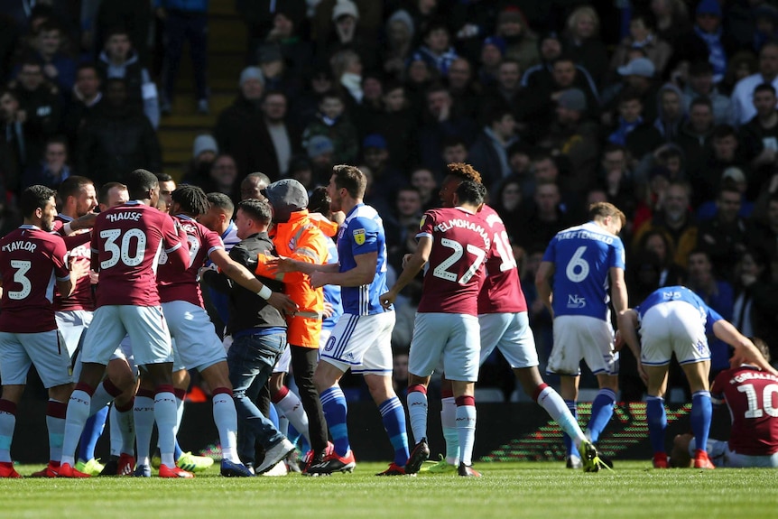 Players from Aston Villa (claret) and Birmingham City (blue) brawl