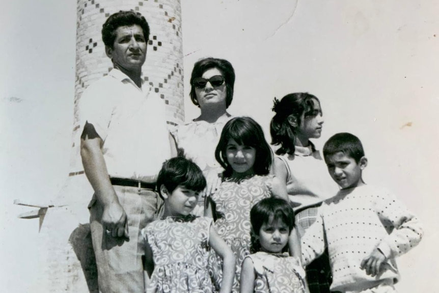 A young family stand in front of a temple.