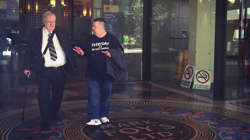 Former Catholic priest Robert Flaherty, 72, walks out of Downing Centre Local Court in Sydney with another man.