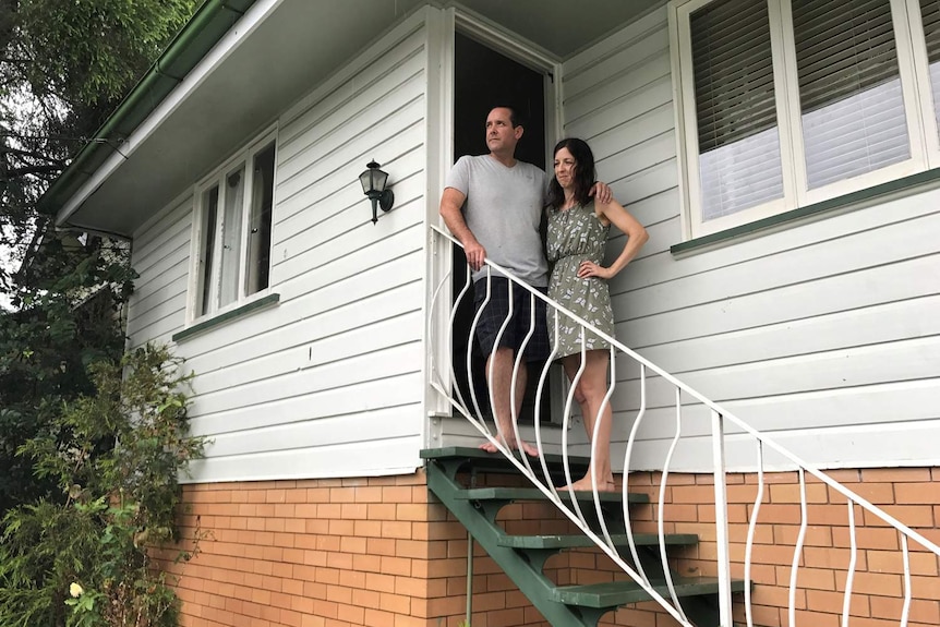 Lizzie Kennedy and her husband standing on the steps of their home.