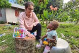 Dr Andrea Burgess plays wth a young child who has been given leg braces for cerebral palsy. 