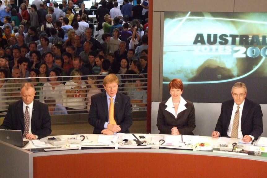 Aerial shot panel with Green, Kerry O'Brien, Julia Gillard and Nick Minchin and crowd in background watching.