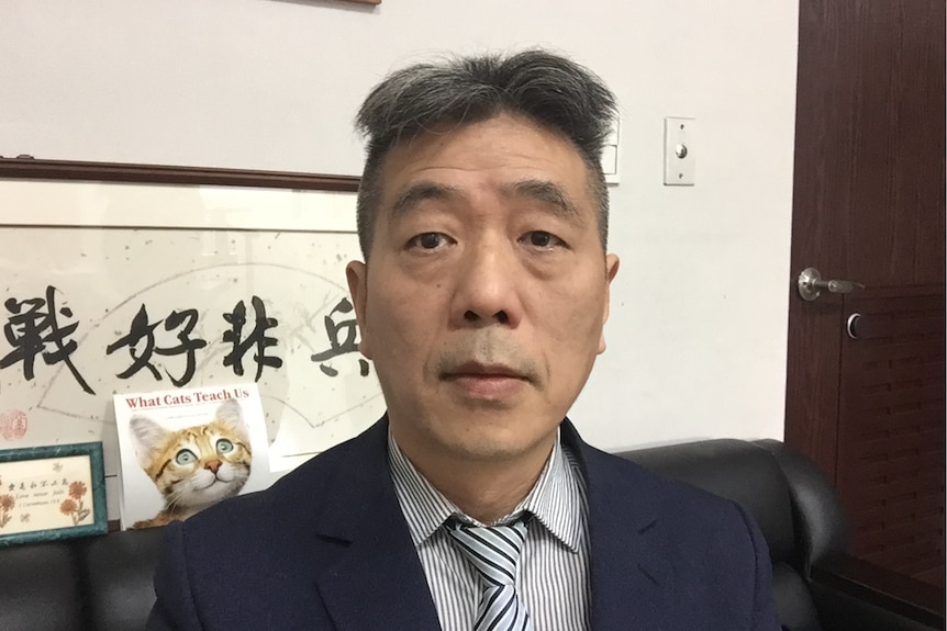 A man in suit sitting in his office