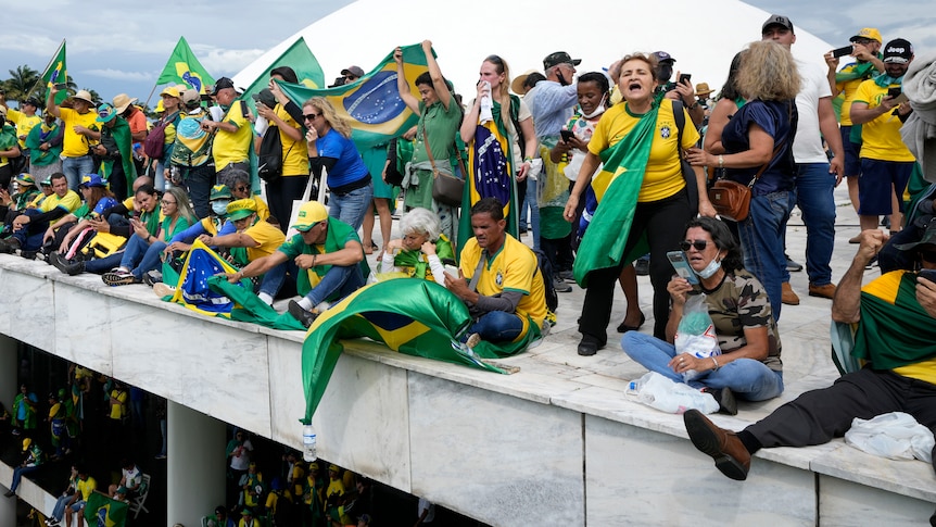 People dressed in green and yellow and draped in Brazil flags