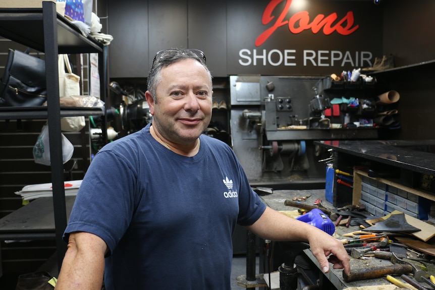 Sam Fazio standing in his shoe repair business looking at the camera