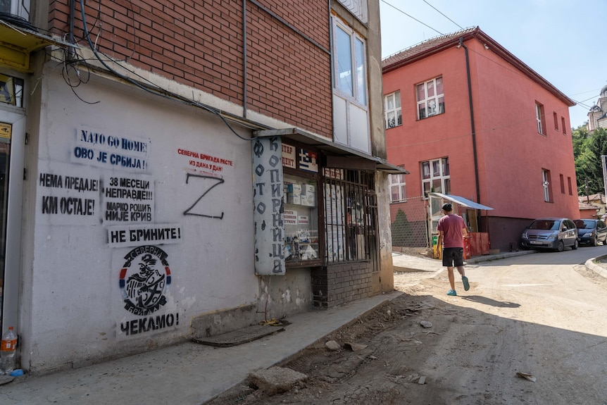 The letter Z is graffitied on a wall on a deserted street.