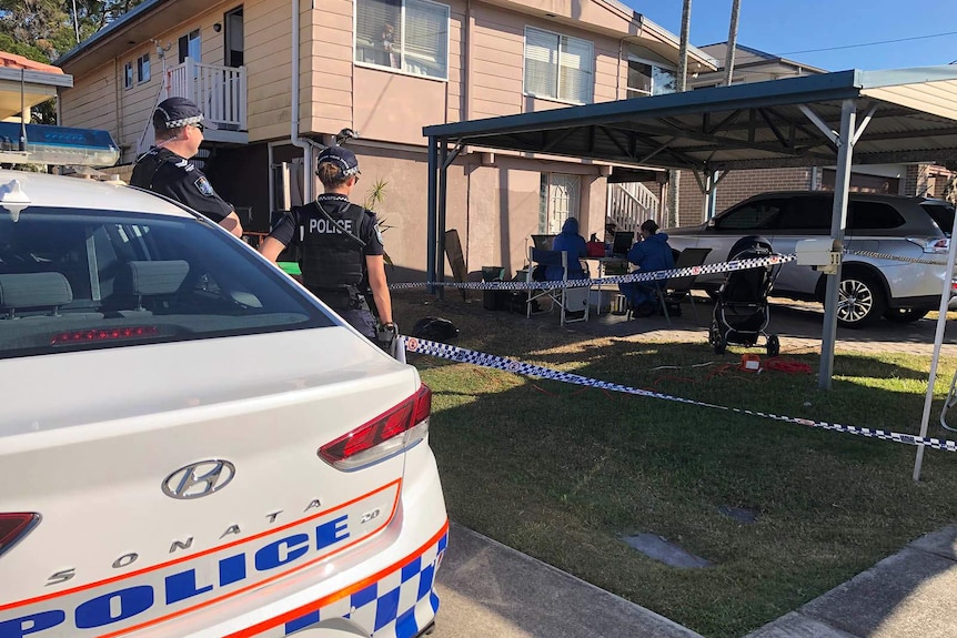 Uniformed and forensic police officers working outside a house