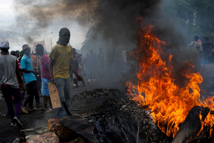 Protestors stand at a burning barricade in Bujumbura, Burundi