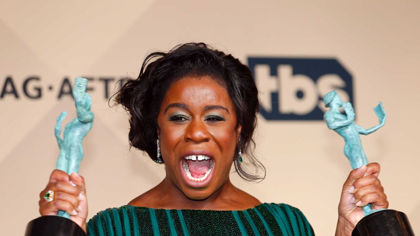 Actress Uzo Aduba holds up two SAG awards