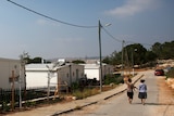 Israeli women walk through the Jewish settlement known as Gevaot