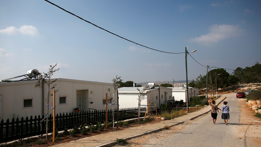 Israeli women walk through the Jewish settlement known as Gevaot