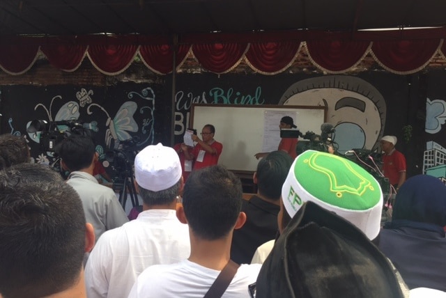 Man reads out ballots at Petamburan polling booth