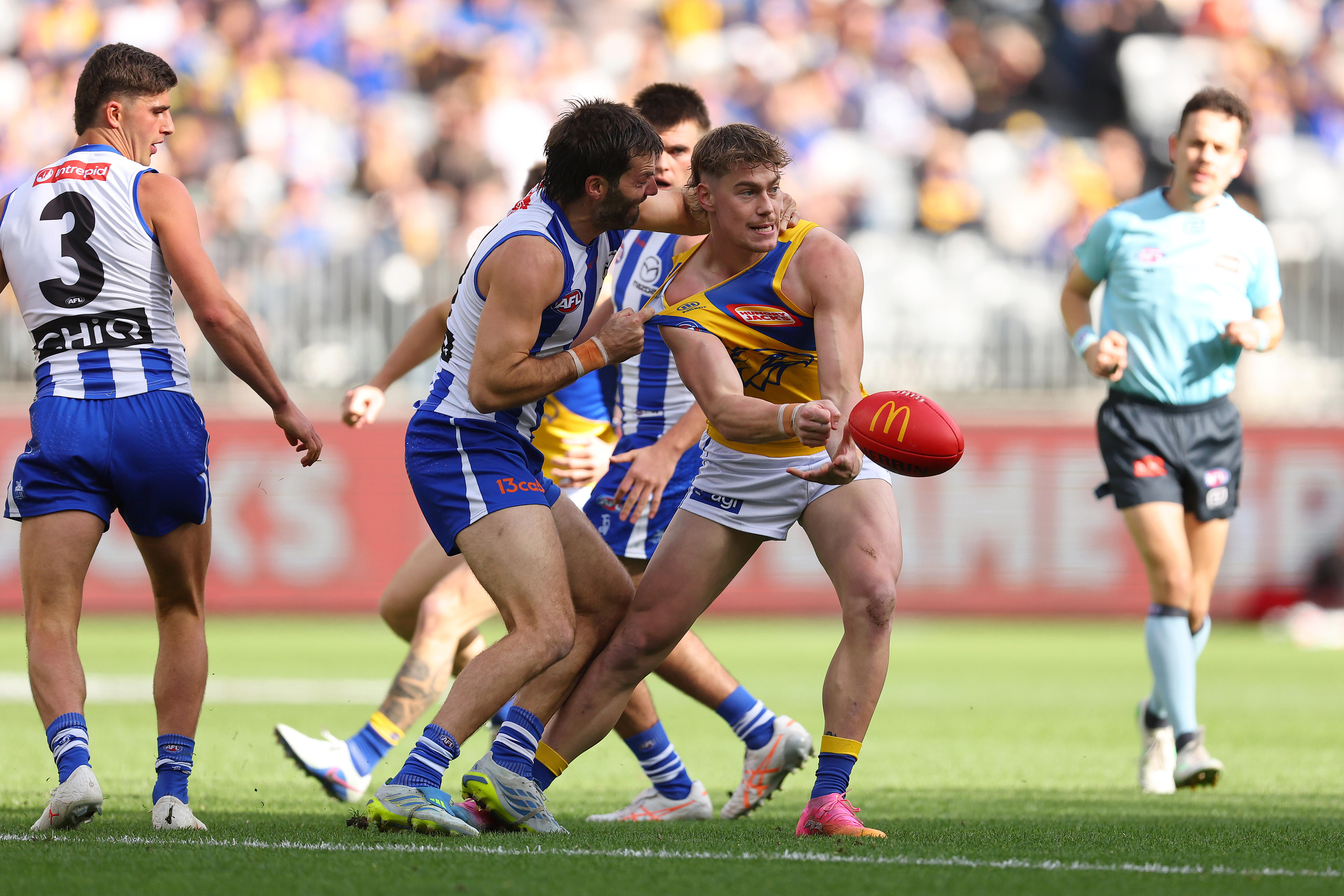 Harley Reid attempts a handpass while being tackled