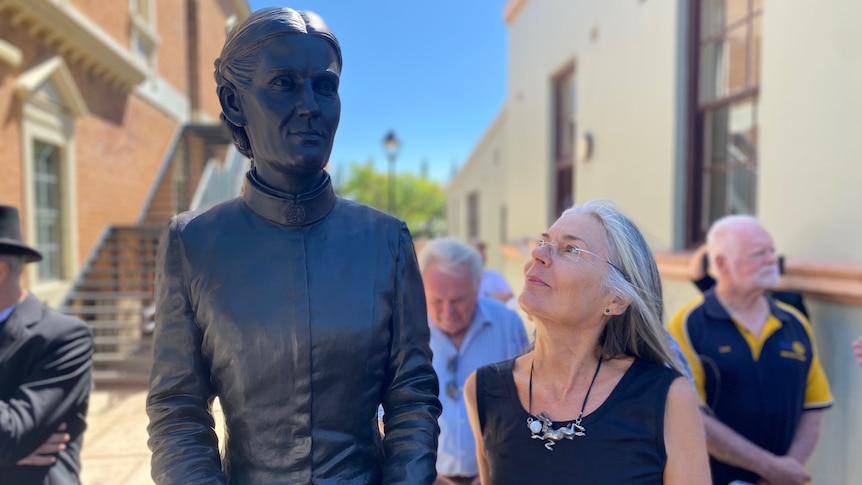 A woman glancing up at a statue