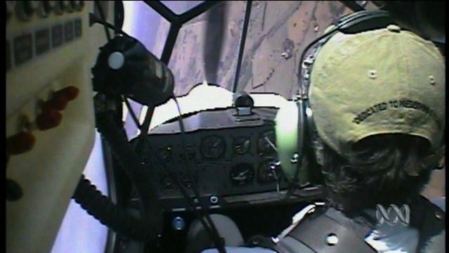 A pilot sits in a plane cockpit