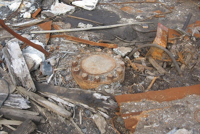 A round lid welded shut among debris