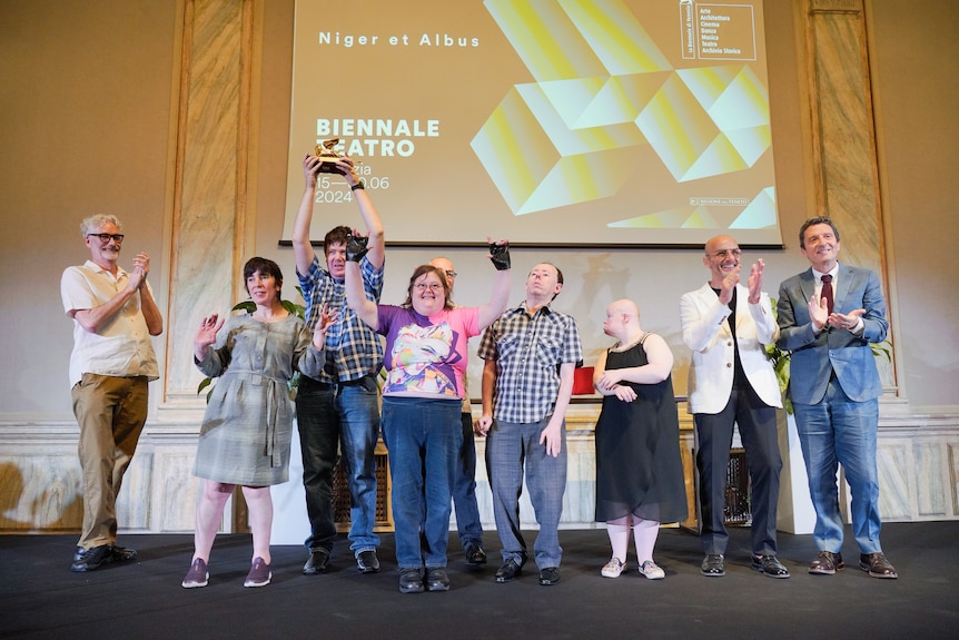 Nine people on a stage at an awards ceremony.