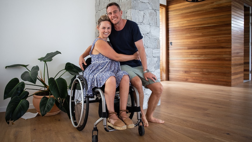 Woman in wheelchair hugging man pictured in story about relationships that include a partner who is a carer.