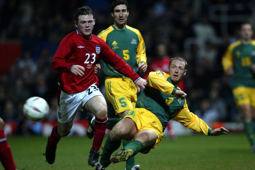 England's Wayne Rooney and Socceroos' Craig Moore compete for the ball during an international football friendly.