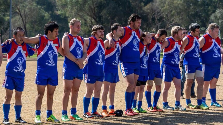 Football team line up. Players wearing red and blue jumpers