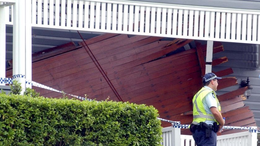 Police officer surveys collapsed balcony