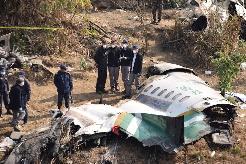 Investigators look at wreckage of a Yeti Airlines plane that crash in Nepal.