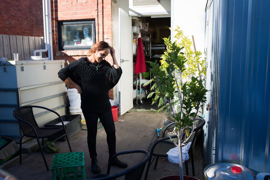 Ravit Gabai is caught in a slice of sun out the back of her kitchen, an apron hanging on the open door behind her.