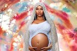 Nicki Minaj holding her pregnant belly, surrounded by foliage, in a Virgin Mary-inspired photo by David LaChapelle.