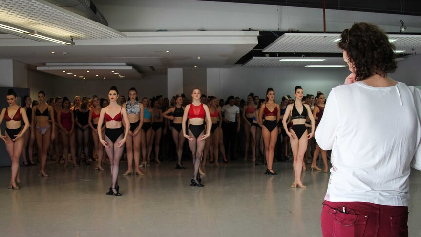 Dancers in lines, waiting to perform for the recruiters.
