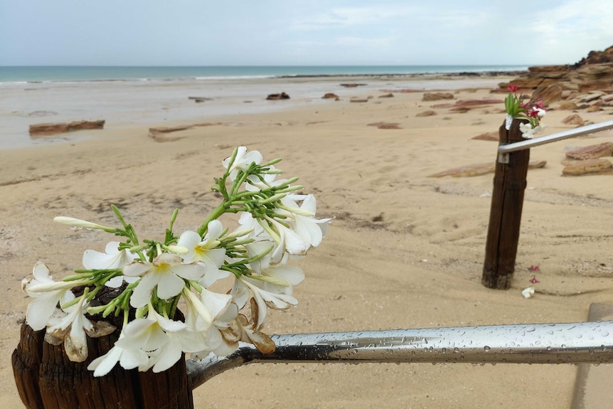 Flowers tied to the railing of a staircase at a beach