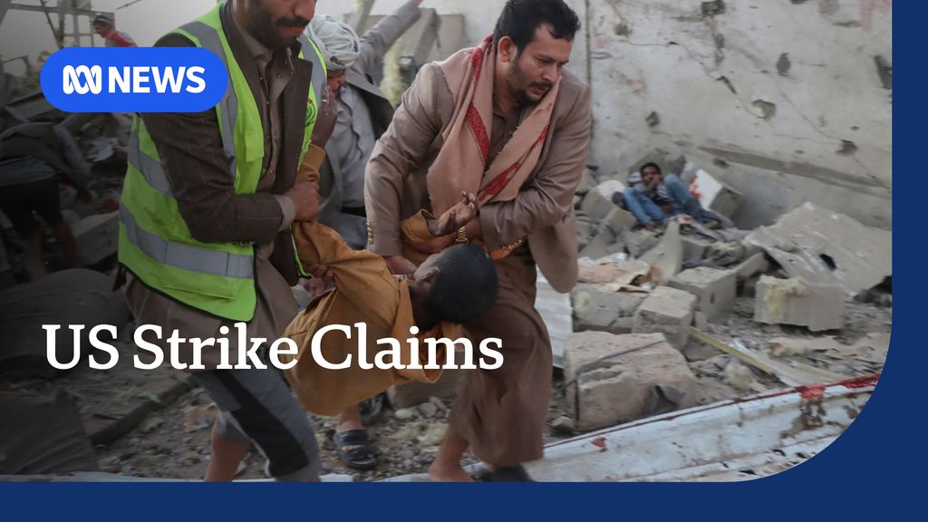 US Strike Claim: Two men in high visibility vests haul a child out of rubble