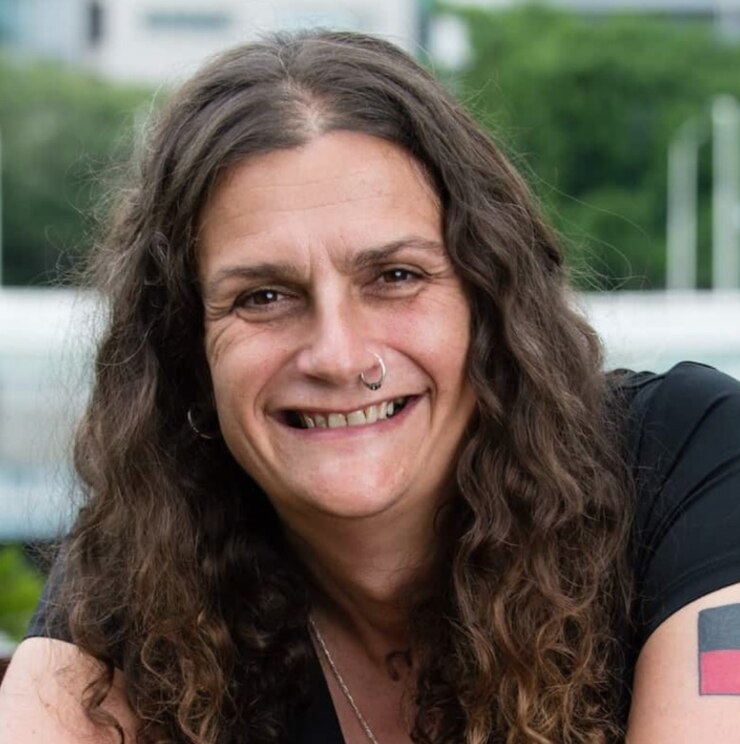woman with dark hair and Aboriginal flag tattoo on her arm 
