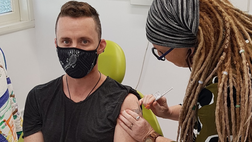 Registered nurse "Scruffy" getting a Pfizer jab from his doctor wife