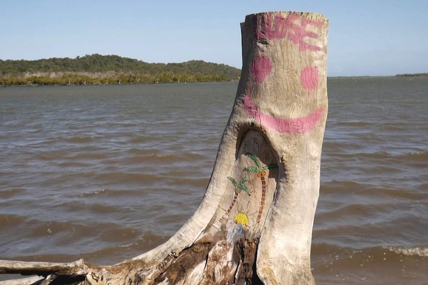 A painted log on the foreshore of an island in Moreton Bay looking out to another island