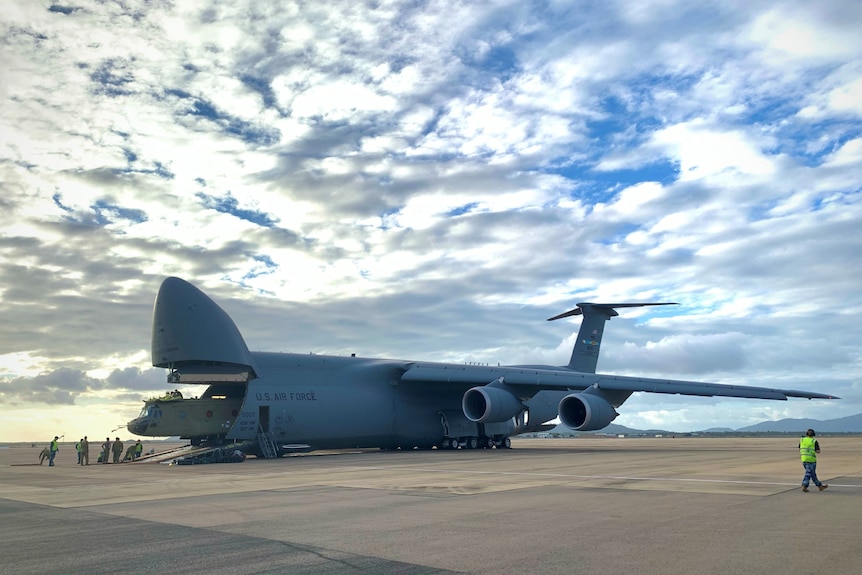 The nose of a US large military cargo plane opens up to reveal its cargo of a Chinook helicopter