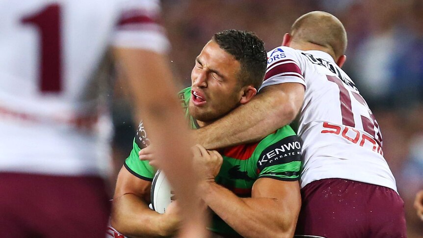 Glenn Stewart lands a high tackle of Sam Burgess of the Rabbitohs