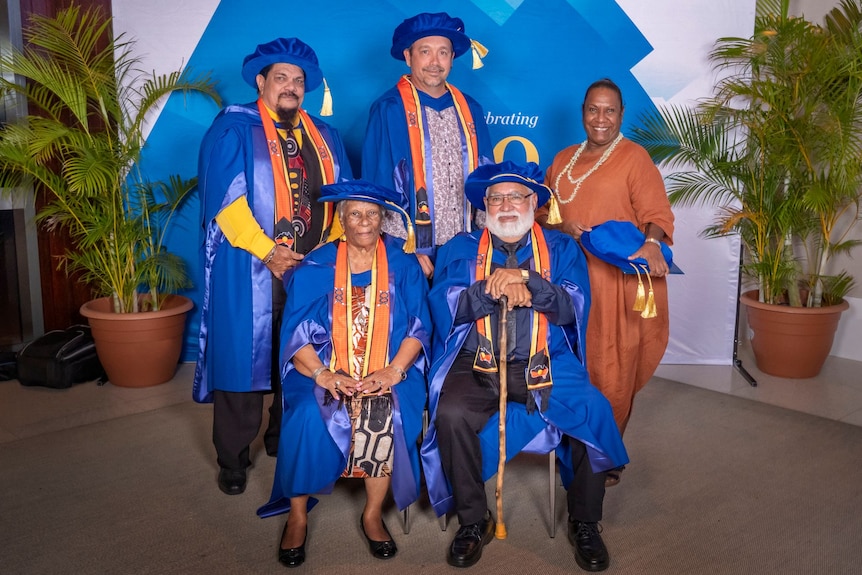 A group of people standing in university regalia.