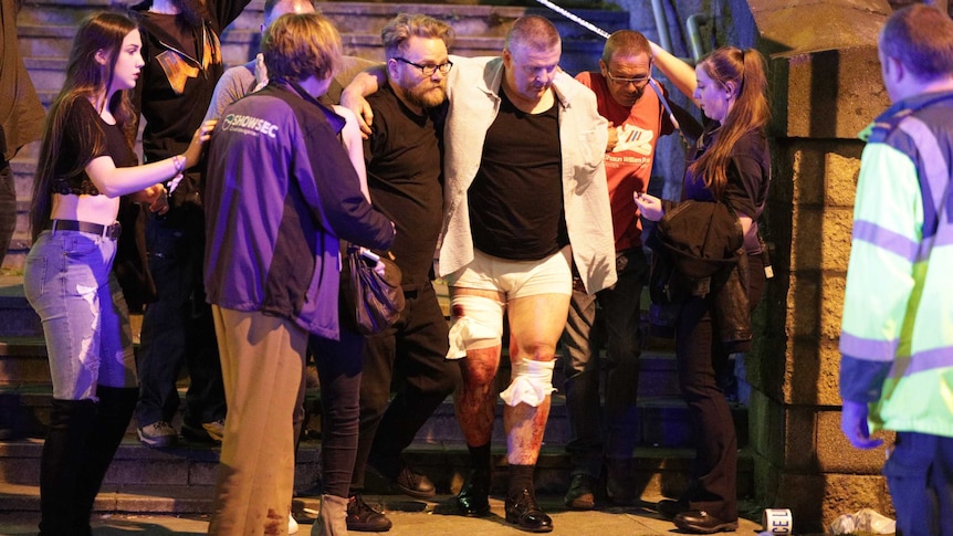 Bystanders assist an injured man near the Manchester Arena.