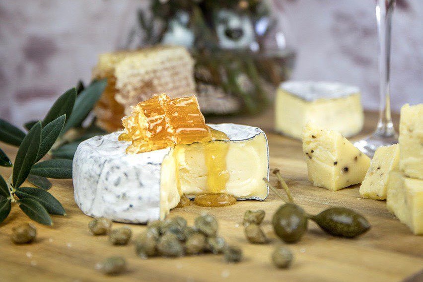 Capers and other cheeses are sprinkled on the soft cheese.